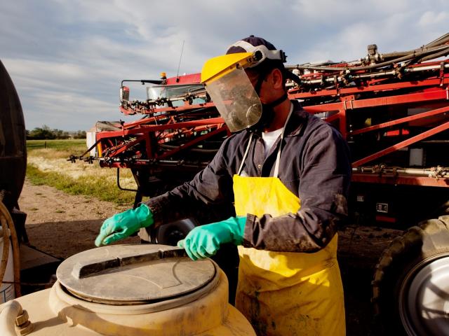 Filling a high clearance sprayer with chemical and water with proper safety equipment 