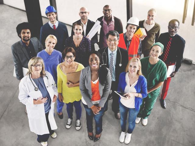 Diverse group people different occupations looking up at camera