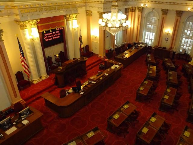 California State Senate assembly room with red carpet and wood desks