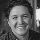 Headshot of smiling Peter James, Sc.D. in a softly lit background in black and white image.