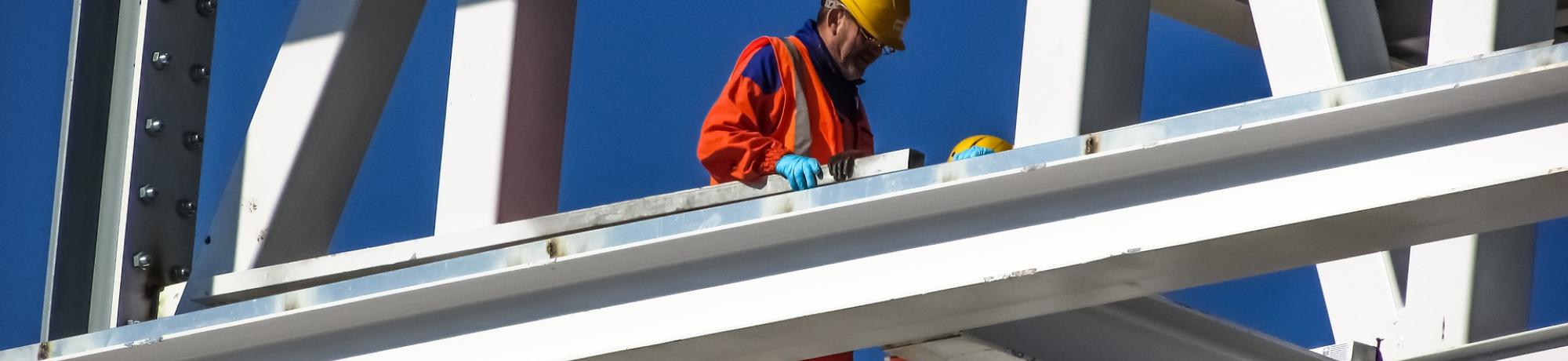 Man in hard hat standing on bridge trusses